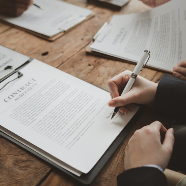 Business people negotiating a contract, discussing contract while working together in sunny modern o